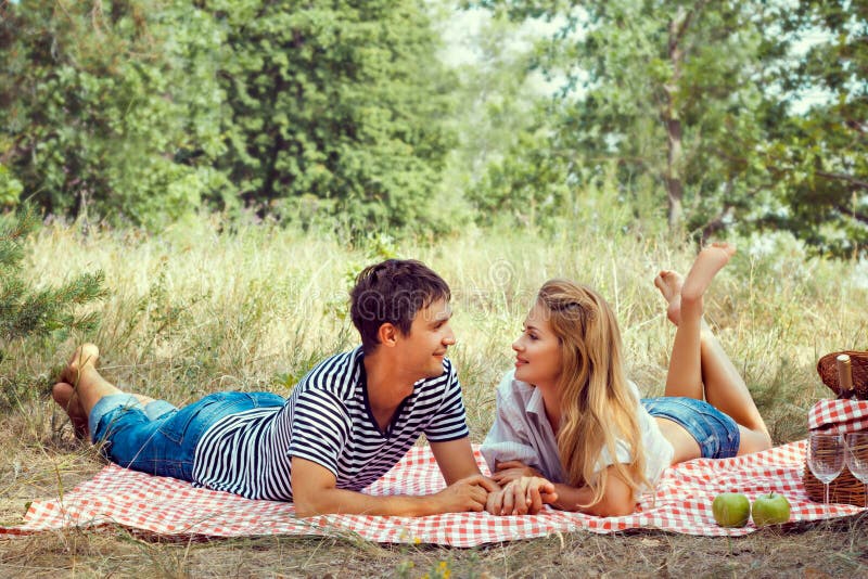 Beautiful couple on picnic, look at each other.