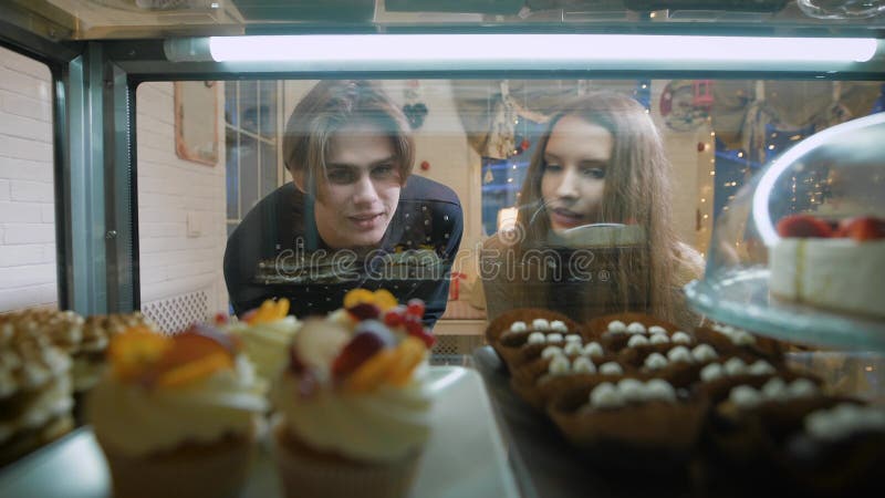 Beautiful couple of young people in a candy store. The girl and the guy on the first date, they have romantic feelings