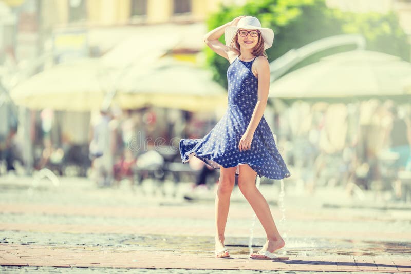 Beautiful cute young girl dancing on the street from happiness.Cute happy girl in summer clothes dancing in the sun stock photo Beautiful cute young girl dancing on the street from happiness.Cute happy girl in summer clothes dancing in the sun stock photo