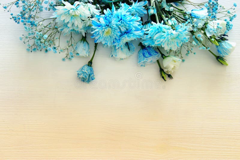 Beautiful and delicate blue flowers arrangement on white wooden background