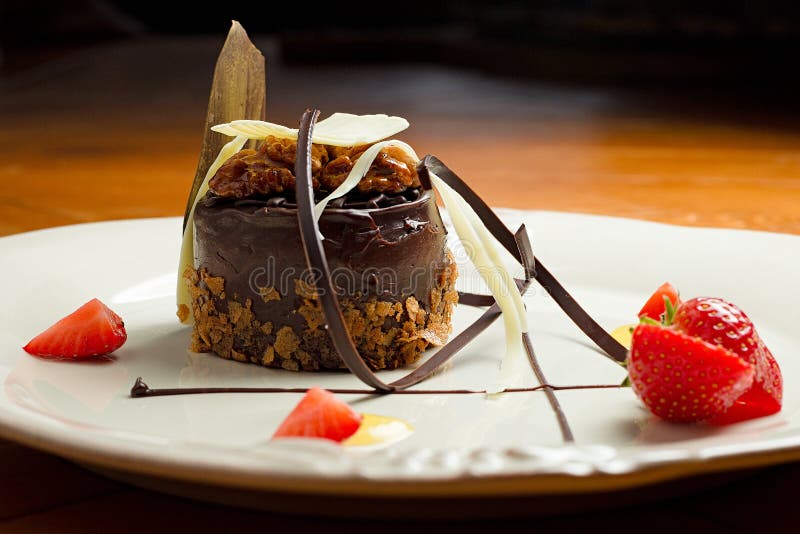 Beautiful Dessert Chocolate Cake with Nuts on a Plate Closeup. Stock