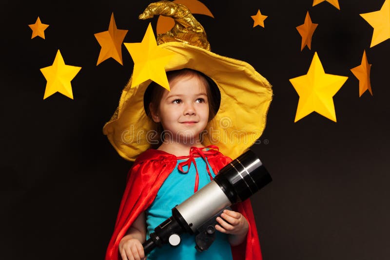 Beautiful little girl in sky watcher costume stargazing through a telescope. Beautiful little girl in sky watcher costume stargazing through a telescope