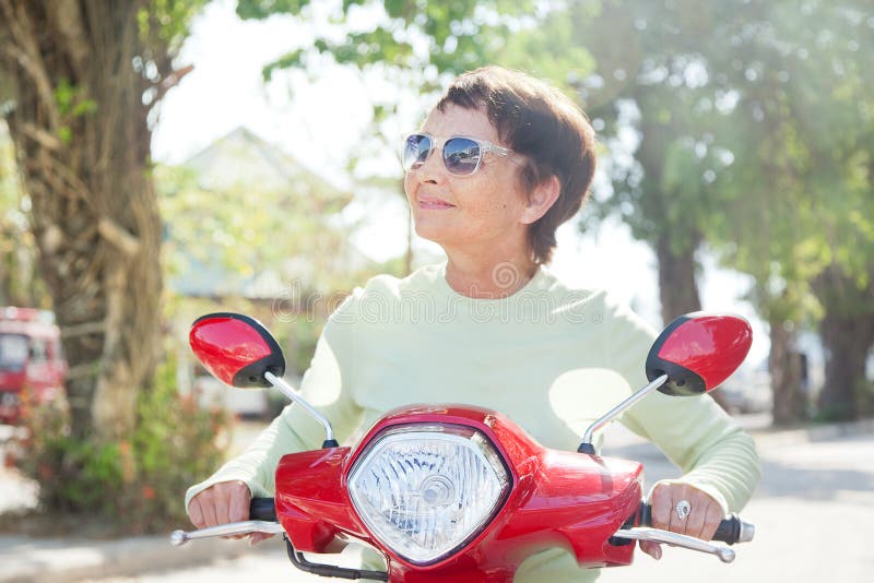 Beautiful elderly woman on motorbike