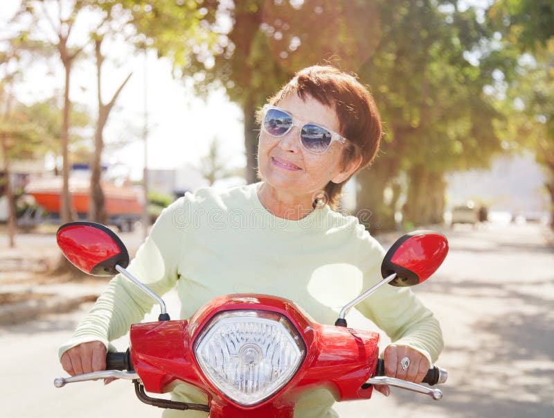 Beautiful elderly woman on motorbike