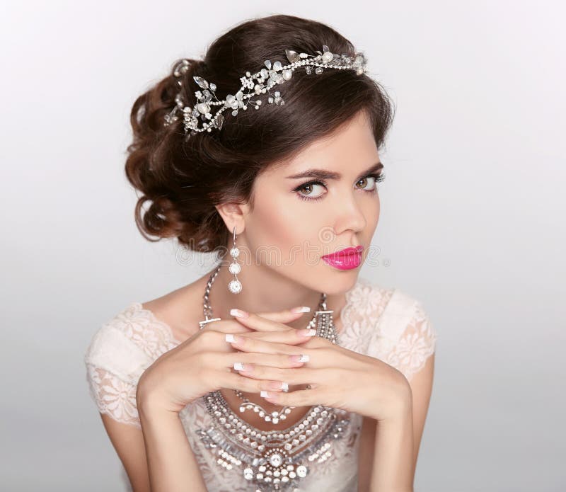 Beautiful elegant girl model with jewelry, makeup and retro hair styling. Manicured nails.