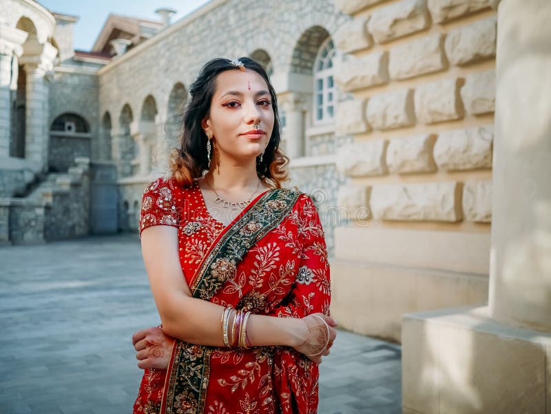 Beautiful ethnic Indian Saree. Young woman in red, colorful, sensual,  wedding and very feminine outfit - Indian sari poses on old streets in  India. .Traditional national clothing of Indian women Stock Photo |