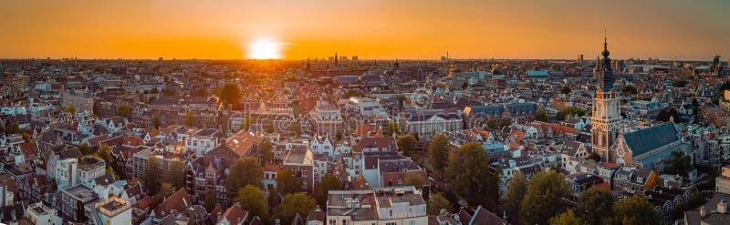 Beautiful evening panorama of Amstedam city looking towards the west with beautiful sunset and sun setting down over Amsterdam.
