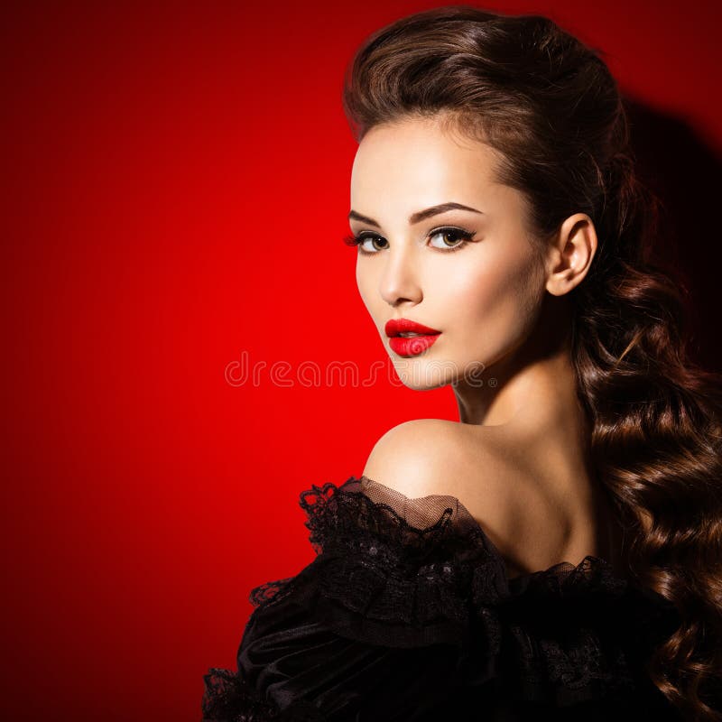 Beautiful face of an young sexy woman in black dress with red lipstick