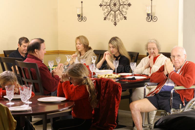 Beautiful family praying at breakfast