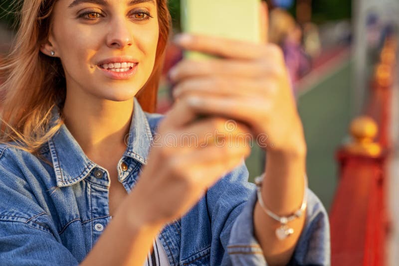Beautiful fashion girl doing selfie with phone at sunset stock photo Beautiful fashion girl doing selfie with phone at sunset stock photo