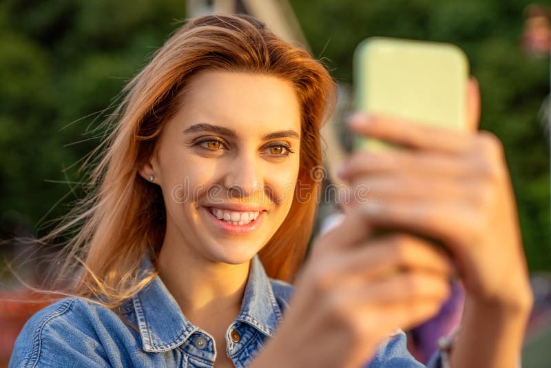 Beautiful fashion girl doing selfie with phone at sunset stock image Beautiful fashion girl doing selfie with phone at sunset stock image