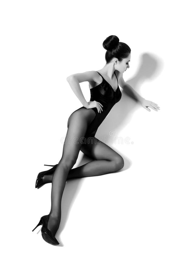 Beautiful fashion model in black swimsuit and hosiery. Young and beautiful woman posing in studio.