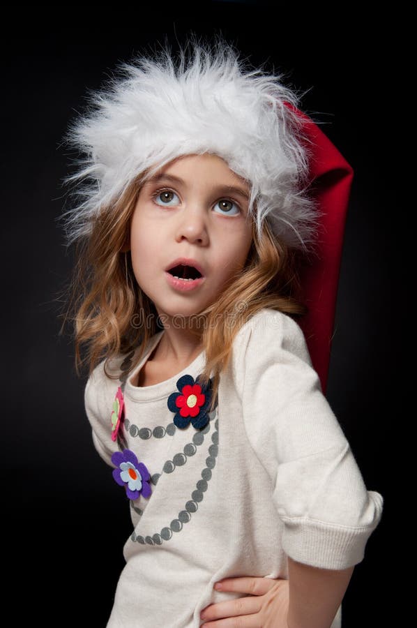 Beautiful fashionable little girl wearing Santa hat