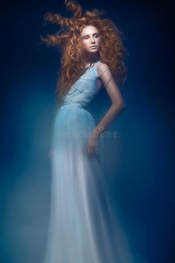 Beautiful fashionable red-haired girl in transparent dress, mermaid image with creative hairstyle curls. Fashion beauty style.