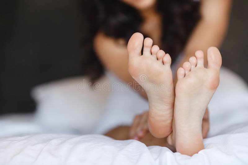 Beautiful feet, lying in the bed of a young woman