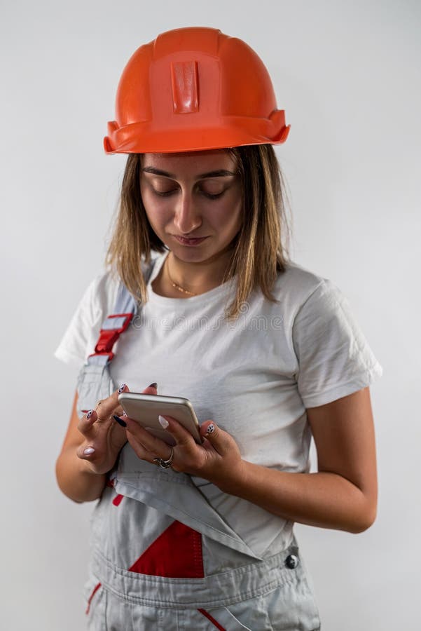 Beautiful female construction worker holding a folder with documents in her hands and smiling stock photo