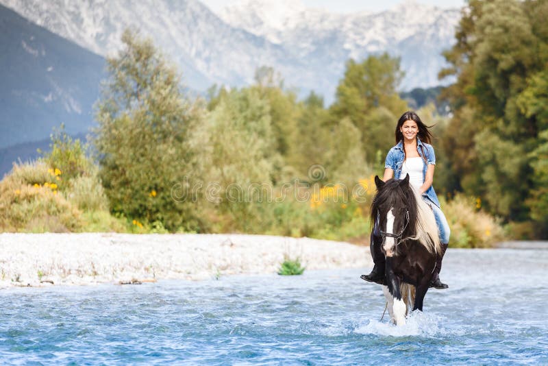 Beautiful Female horse rider crossing river