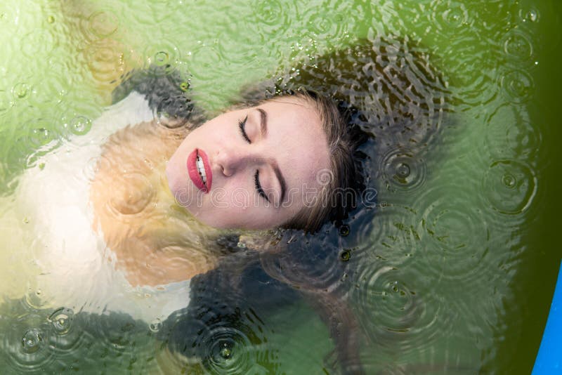 Beautiful Female Model Dressed in Long Evening Gowns, Lies in the Pool ...