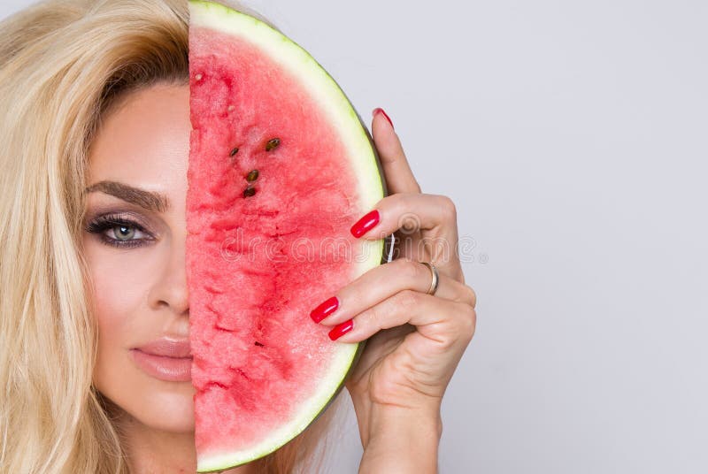 Beautiful female model with long blond hair, holding a watermelon royalty free stock images Beautiful female model with long blond hair, holding a watermelon royalty free stock images
