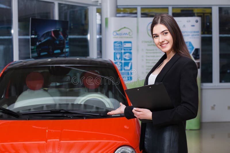 Beautiful female seller shows the car royalty free stock photos Beautiful female seller shows the car royalty free stock photos