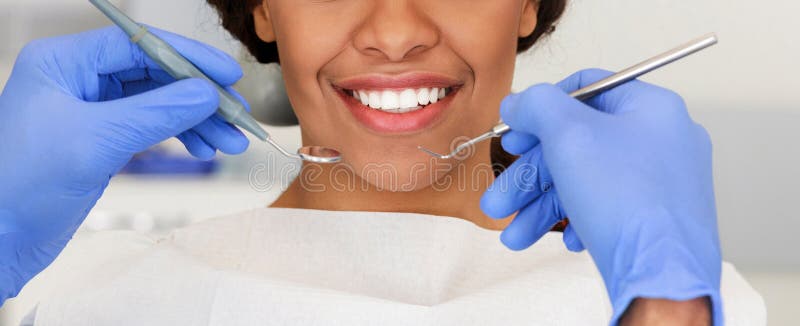 Beautiful female smile and dentist hands with tools