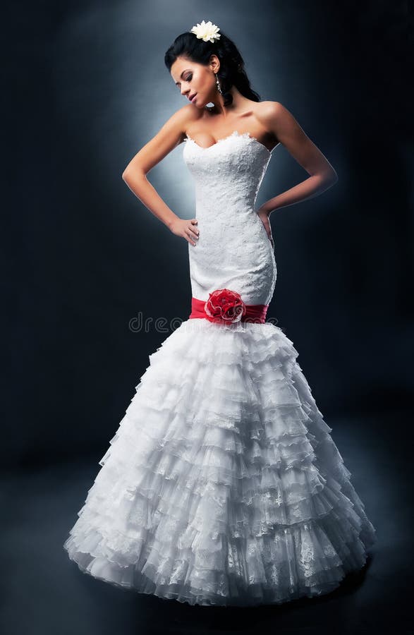 Beautiful fiancee in nuptial dress with red bow