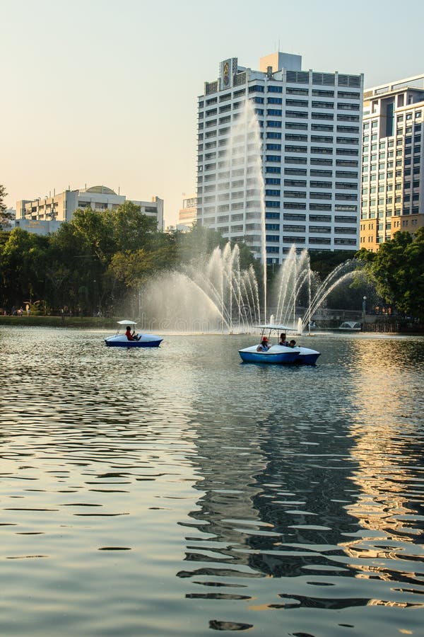Beautiful fountains in the lake at Lumpini Park, Bangkok Thailand. Tranquil public park garden with pond, fountain, and boats in. The middle of the city for royalty free stock photography Beautiful fountains in the lake at Lumpini Park, Bangkok Thailand. Tranquil public park garden with pond, fountain, and boats in. The middle of the city for royalty free stock photography