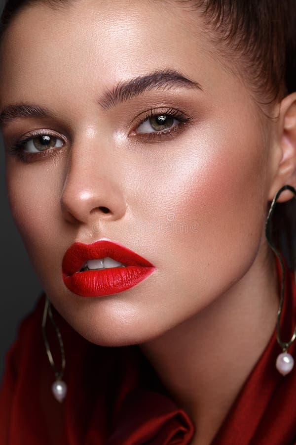 Beautiful fresh girl with classic make-up, smooth hair in a red dress. Beauty face. royalty free stock photos Beautiful fresh girl with classic make-up, smooth hair in a red dress. Beauty face. royalty free stock photos