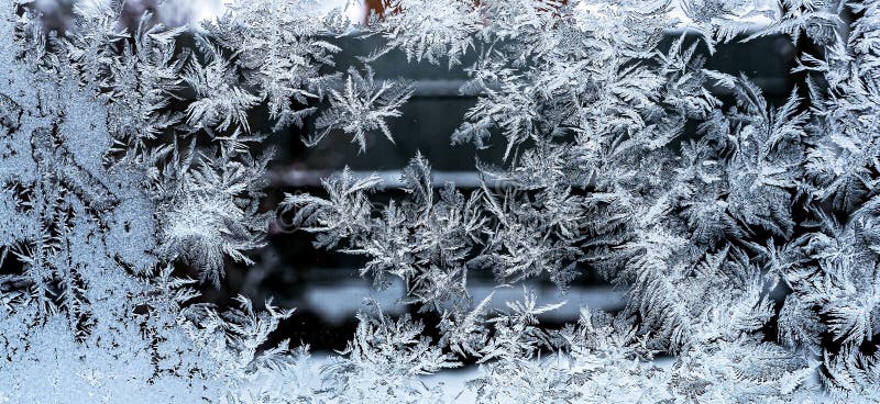 Beautiful frosty patterns on the winter window, texture of frosty patterns. Frosty natural pattern on a winter window, texture of frosty patterns, dendritic image structure