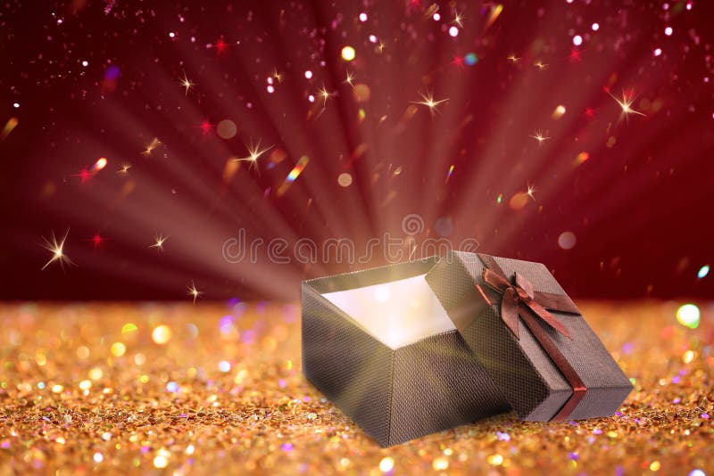 Beautiful Gift Box with Magic Light on Golden Glitters Stock Photo