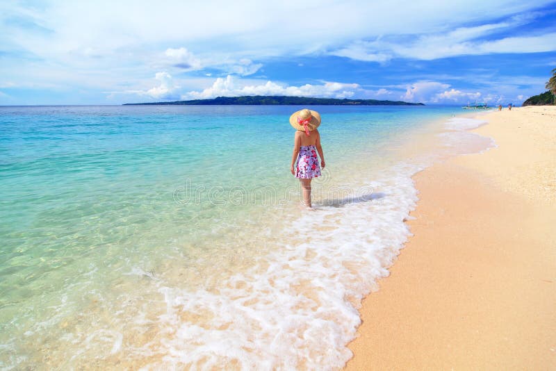 Beautiful girl at the beach with sunny sky, cloud