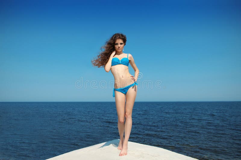 Beautiful Girl in bikini over blue sky on beach