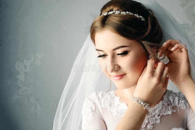 Beautiful girl, bride in a white dress on the background of the apartment. Wedding, bride`s gathering, family creation stock photography Beautiful girl, bride in a white dress on the background of the apartment. Wedding, bride`s gathering, family creation stock photography