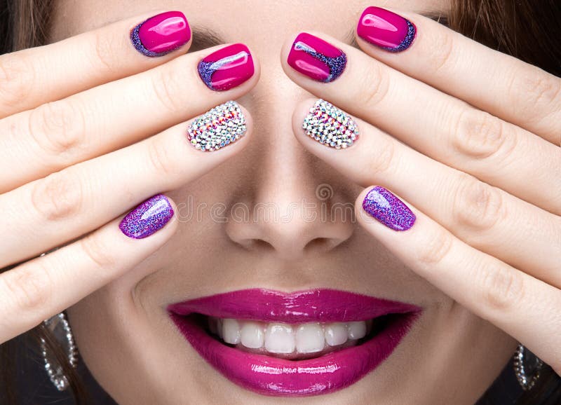 Beautiful girl with a bright evening make-up and pink manicure with rhinestones. Nail design. Beauty face.