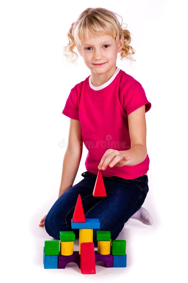 Beautiful girl building a castle with cubes