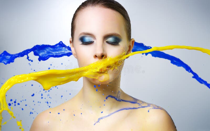 Beautiful girl and colorful paint splashes royalty free stock photography