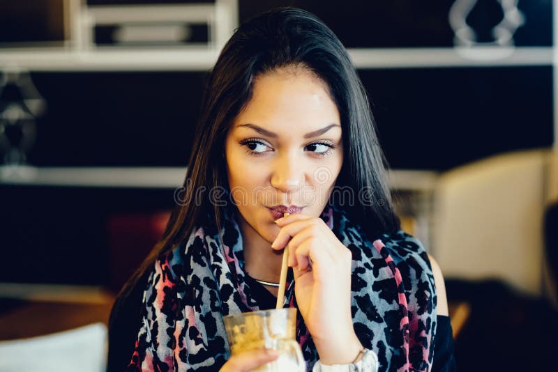 Beautiful girl drinking ice mocha shake in a cafe royalty free stock photography Beautiful girl drinking ice mocha shake in a cafe royalty free stock photography