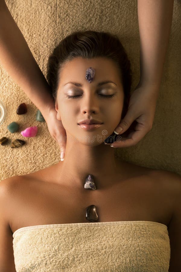 Beautiful girl has massage with chakra-stones