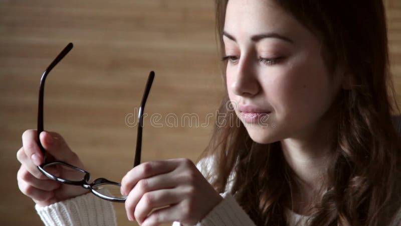 Beautiful girl holding a black-framed glasses