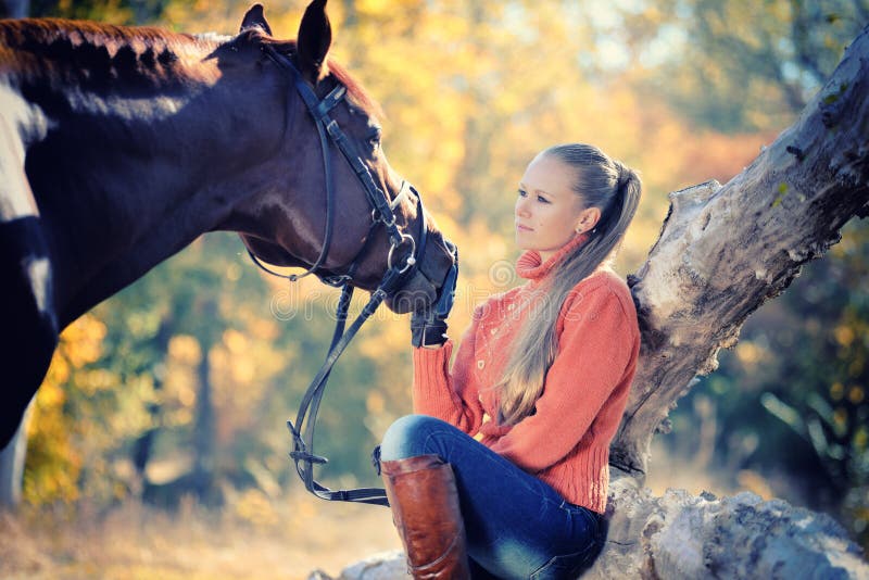 Beautiful girl with horse in autumn forest
