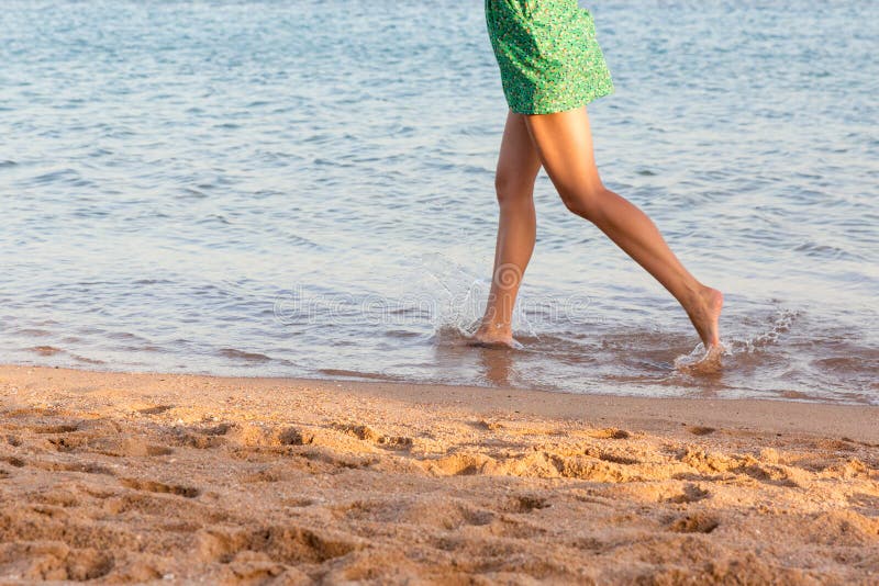 Beautiful girl legs running on the beach. pretty girl walking on water stock photography Beautiful girl legs running on the beach. pretty girl walking on water stock photography