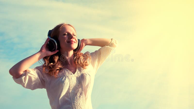Bella ragazza ascoltando la musica con le cuffie in cielo.