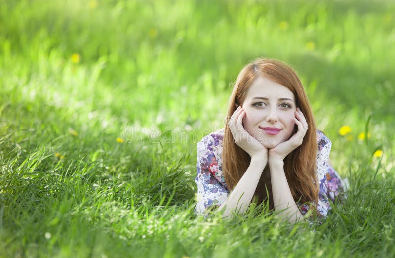 Beautiful girl lying down at grass.