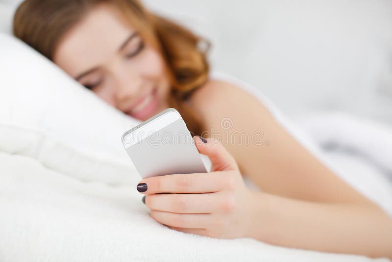 Beautiful girl making selfie in the bed.