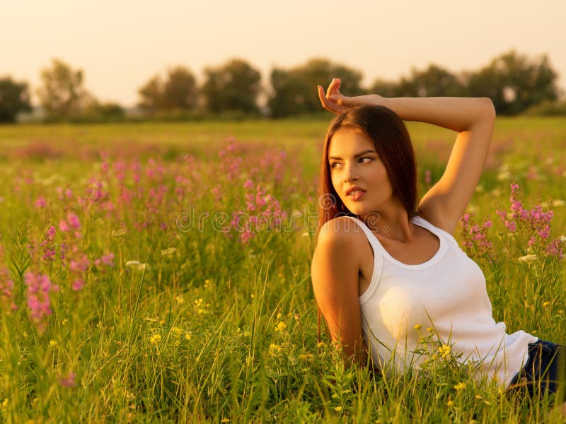 Beautiful Girl Is On Nature On The Spring Wildflowers Background Stock