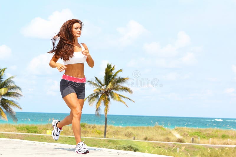 Beautiful girl with nice body running near ocean