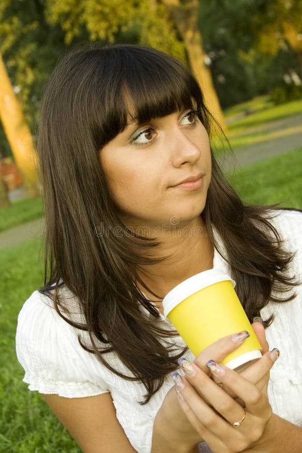 Beautiful girl in the park with coffee