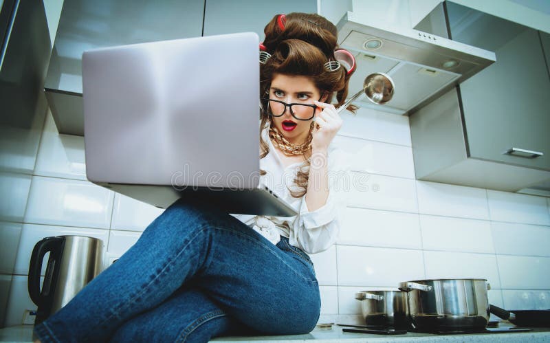 Woman in hair curlers taking funny selfie on mobile while cooking in the  kitchen Stock Photo - Alamy