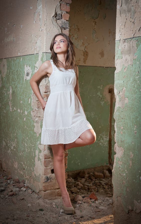 Beautiful girl posing fashion near an old wall