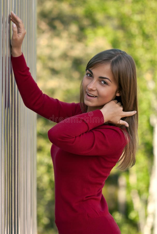 Beautiful girl in purple dress outside steel wall